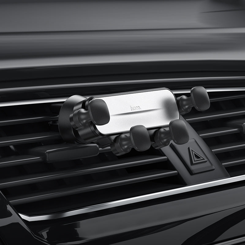Hoco CA102 retractable gravity air vent car phone holder attached to vehicle air vent with phone secured in place.