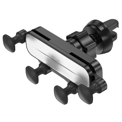 Hoco CA102 retractable gravity car phone holder mounted on dashboard, holding a smartphone securely with automatic grip mechanism.
